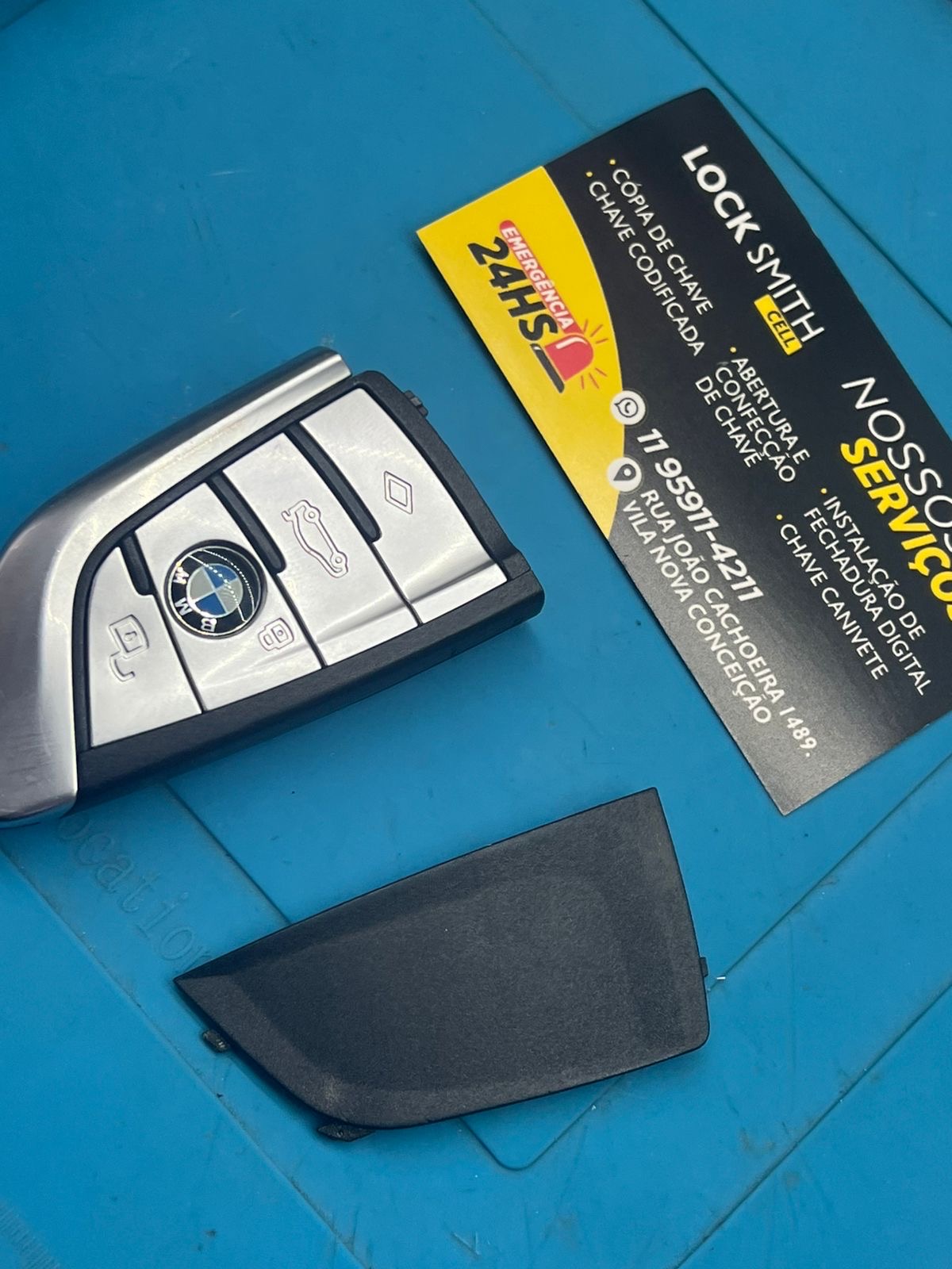 Chave codificada de BMW aberta para reparo ao lado do cartão da Locksmithcell